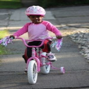A girl in pink riding a bike