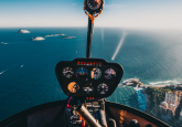 Helicopter cockpit view over coastline