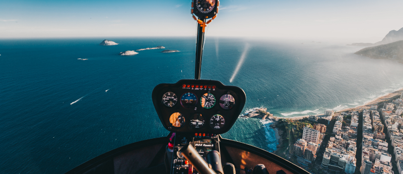 Helicopter cockpit view over coastline