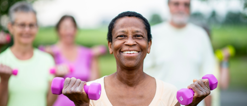 group of elderly people exercising with weights