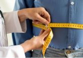 Doctor measuring patient's weight with tape measure