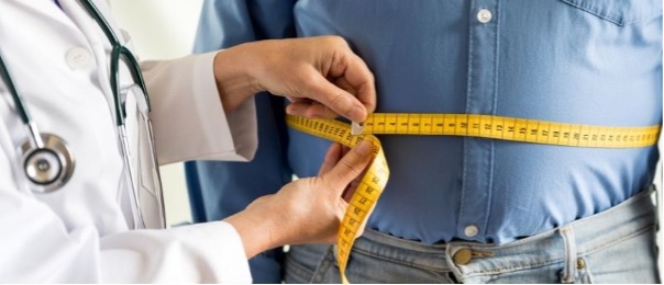 Doctor measuring patient's weight with tape measure