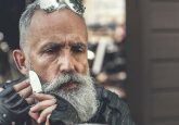 Biker with Beard shaving with knife